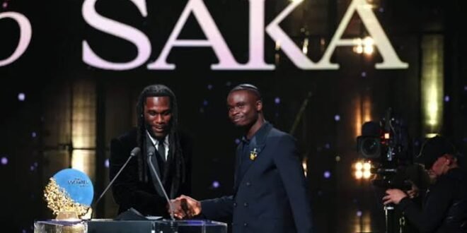 Burna Boy presents the Socrates Award to Bukayo Saka at the 2026 Ballon d’Or